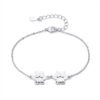 A minimalist, mirror-polished silver stainless steel bracelet featuring two interconnected paw-print charms and a secure lobster clasp.