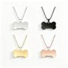 Four finished stainless steel dog bone pendant necklaces in silver, black, gold, and rose gold with bead chains for volume wholesale sourcing.