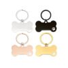 Wholesale custom stainless steel dog bone keychains in silver, rose gold, black, and gold finishes with engraved pet paw icons and split rings.