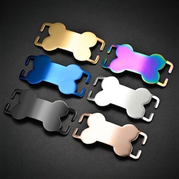 Six mirror-polished stainless steel slide-on bone collar tags in gold, rainbow, blue, silver, black, and rose gold finishes, arranged diagonally on a black background.
