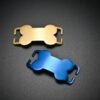 Top view of a gold and a royal blue stainless steel curved bone charm blank with open side slots, isolated on a dark grey matte surface.