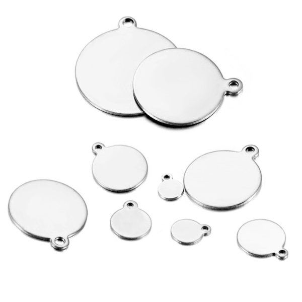 An array of silver stainless steel circular tags with exterior top loops in various scaled sizes, scattered on a plain white background.