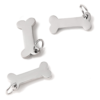 Three mirror-polished silver stainless steel mini bone charms with attached split rings scattered on a clean white surface.