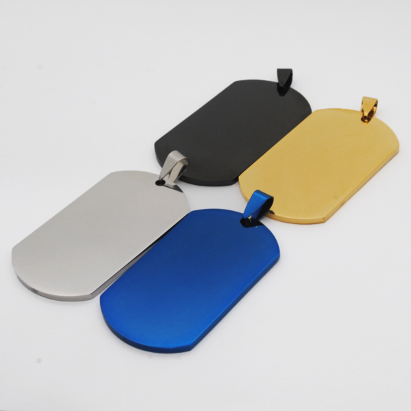 Four heavy-duty stainless steel dog tags in brushed silver, matte black, gold, and blue finishes, arranged overlapping each other on a smooth white surface.