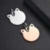 Two mirror-polished stainless steel cutout ear cat tags in silver and rose gold finishes, linked together on a dark surface.